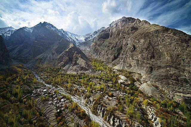 Terraced village on a steep rocky mountainside above a stream
